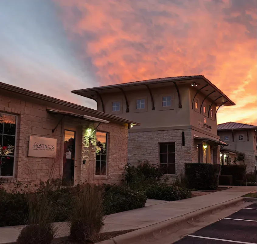 Staats Psychiatric Services office building entrance at dusk with lit signage