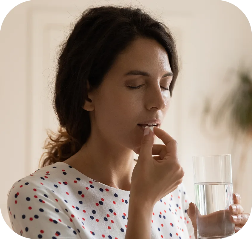 Woman taking medication with a glass of water