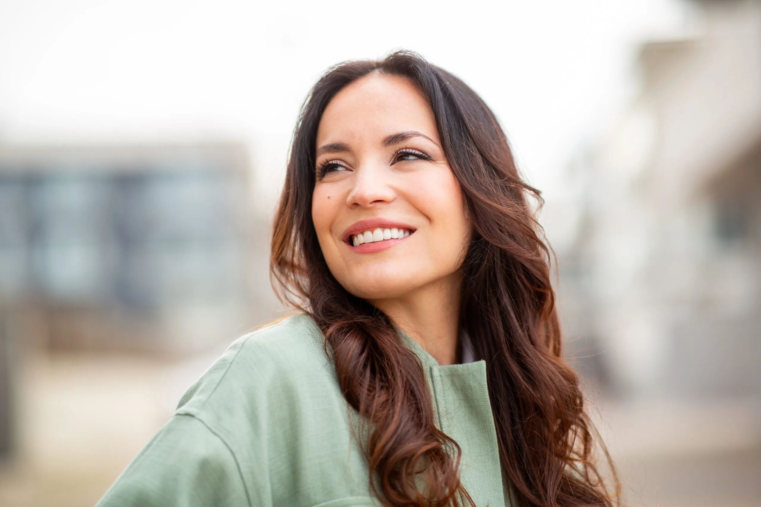 Woman smiling outdoors in casual green shirt