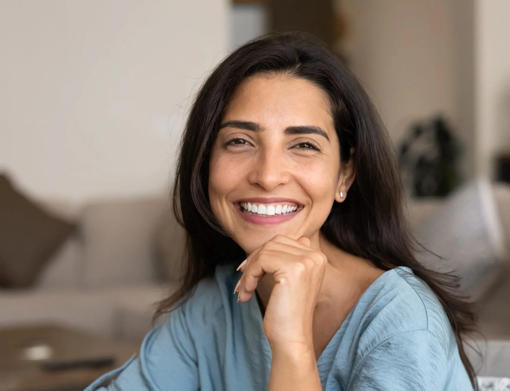 Woman smiling at home in a casual blue shirt