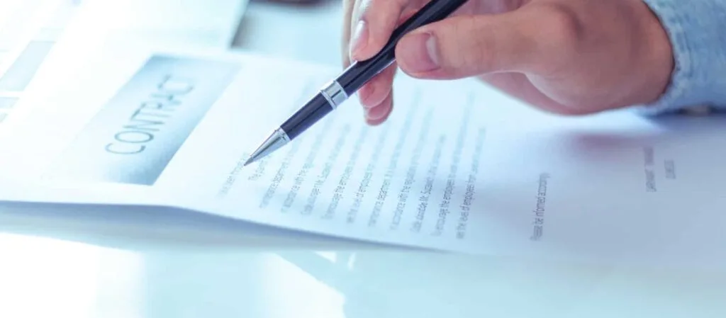Person holding pen over solar quote document for review and comparison