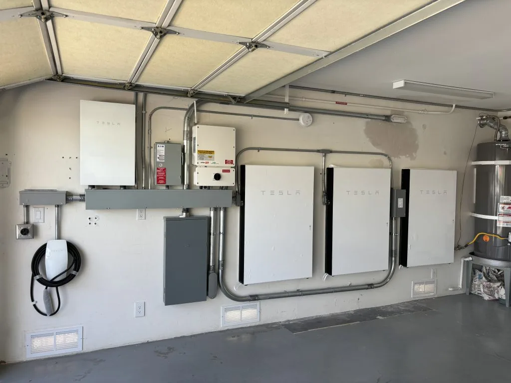 Tesla Powerwall battery units and electrical components installed in a garage