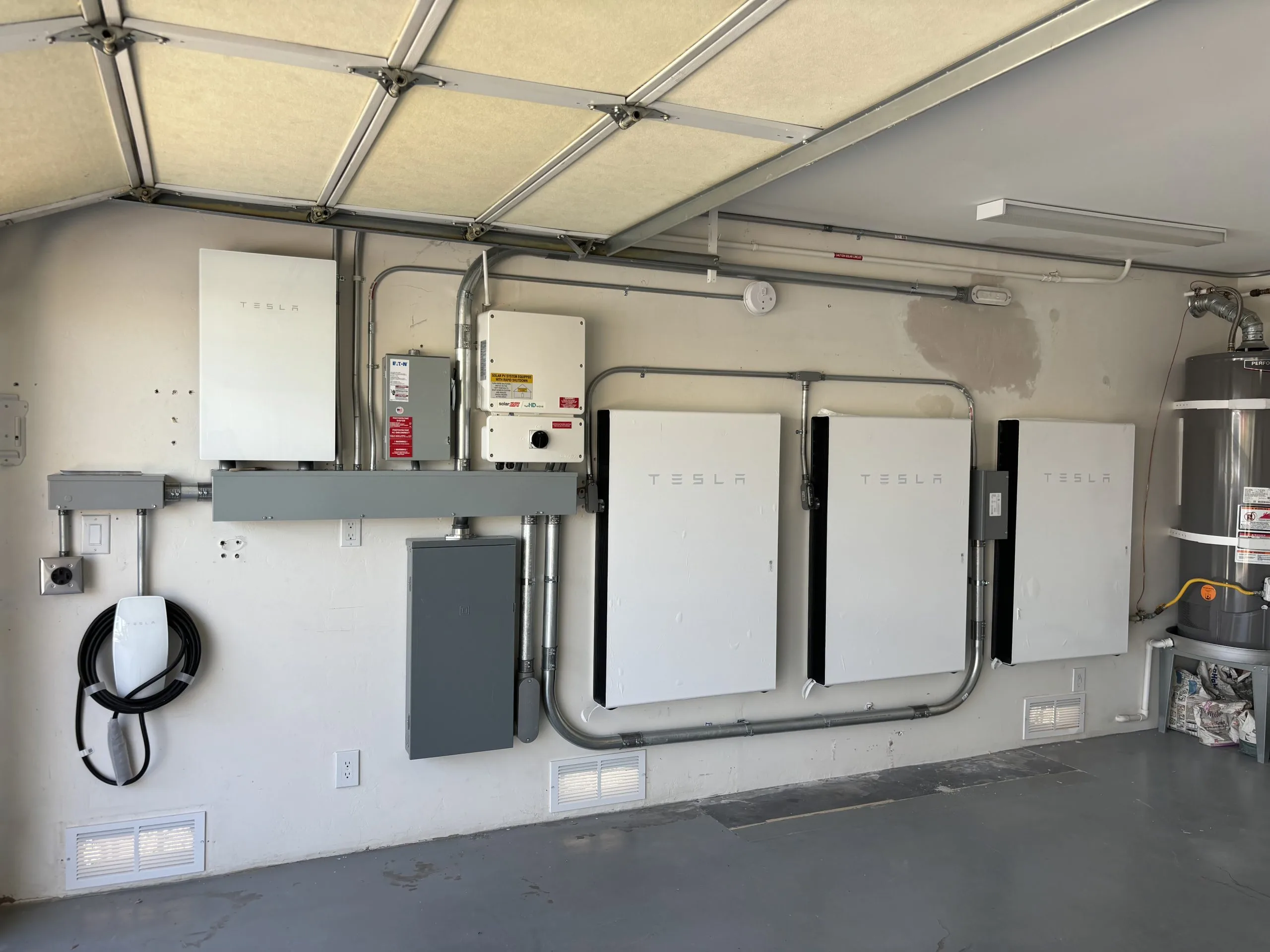 Tesla Powerwall battery units and electrical components installed in a garage