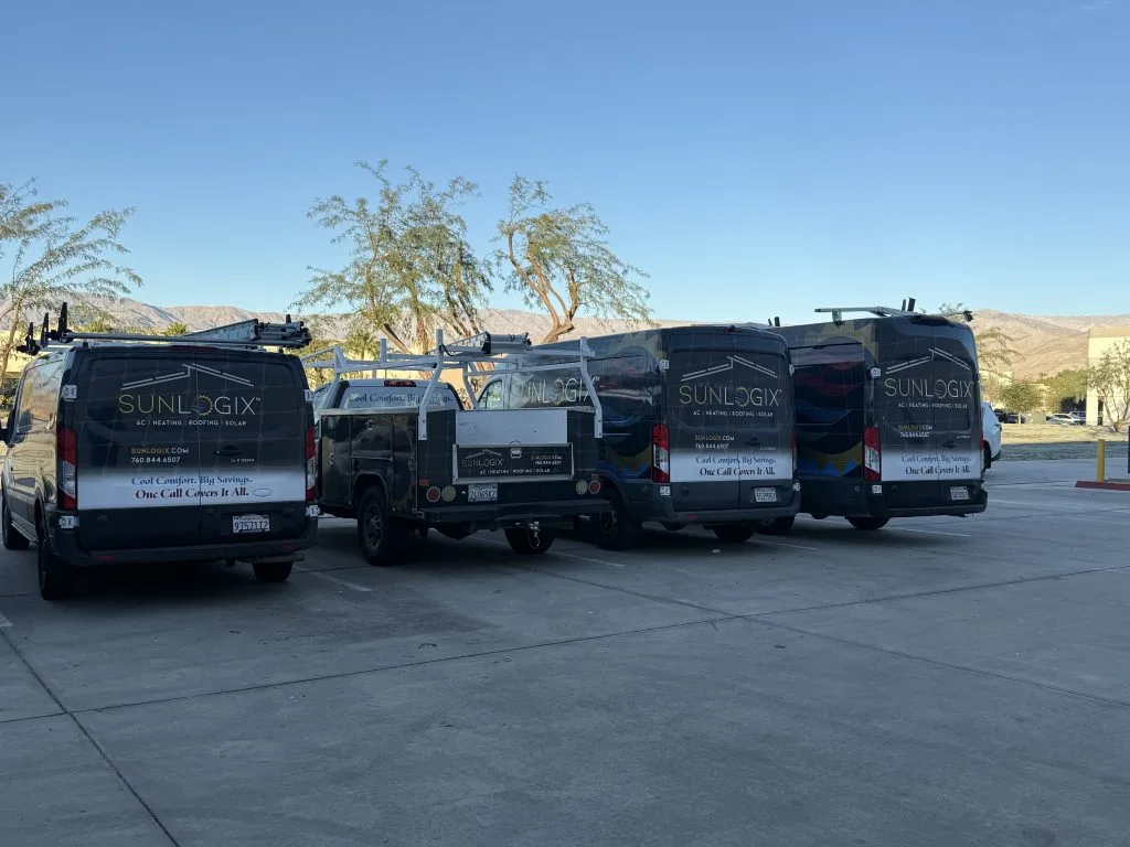 Five Sunlogix service vans lined up in parking lot with desert mountains in background