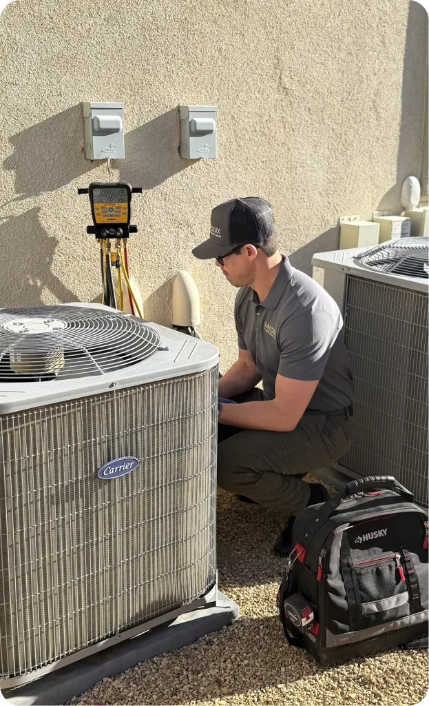 Technician servicing a Carrier air conditioning unit outside a residential building
