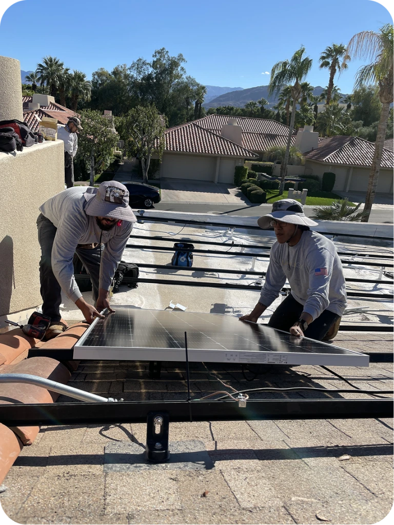 Two installers positioning solar panels on residential rooftop