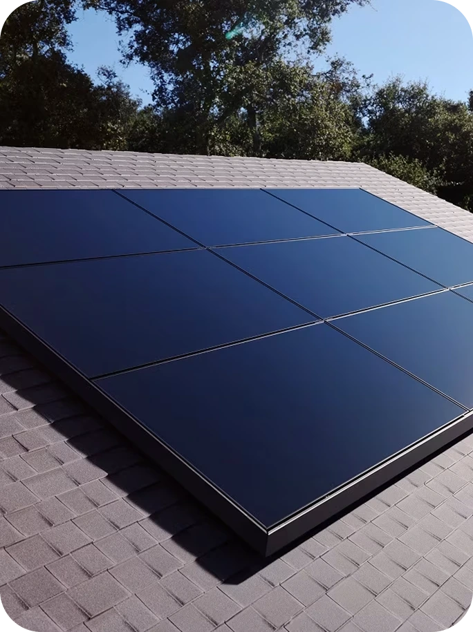 Tesla solar panels installed on residential roof with trees in background
