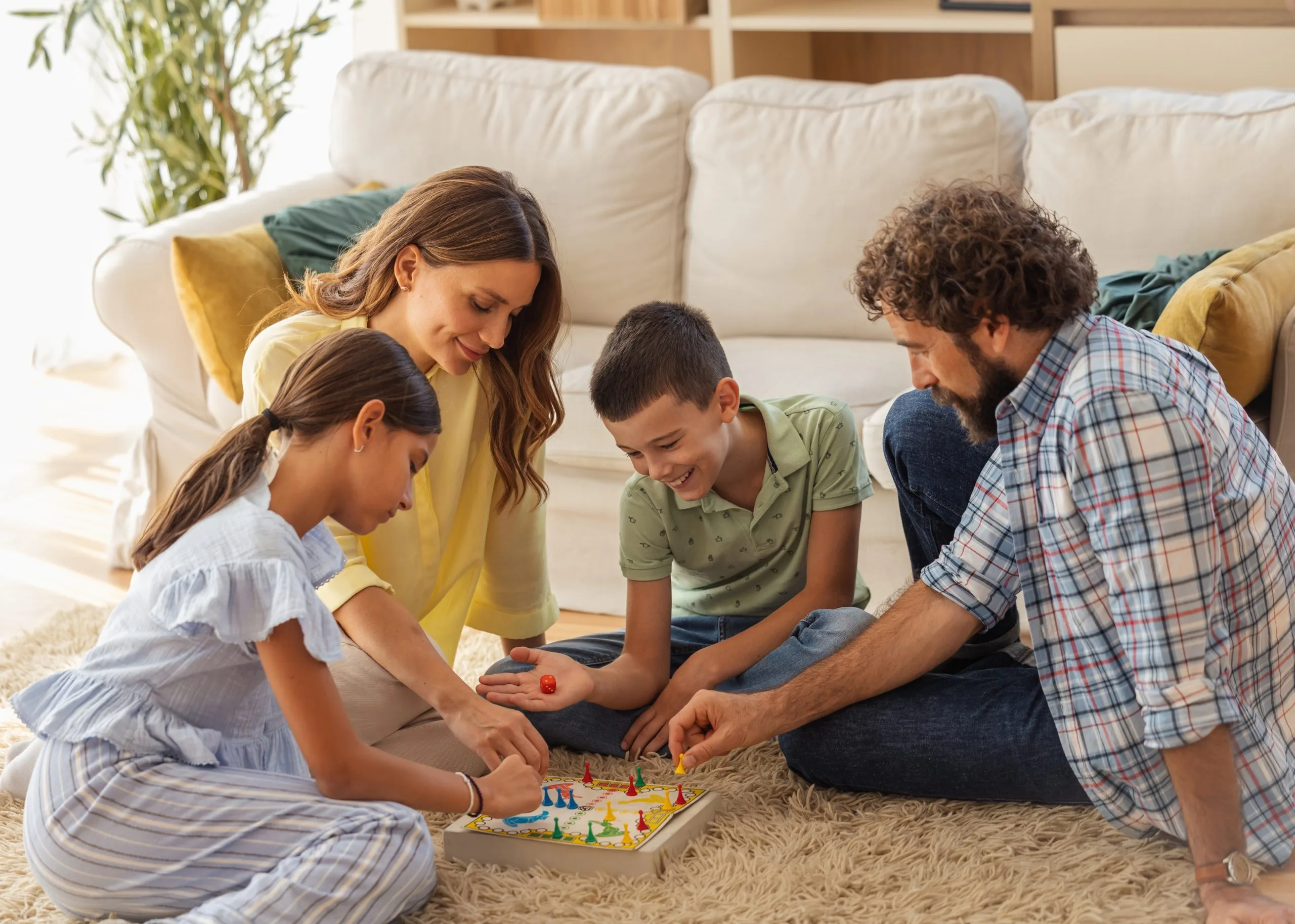Family playing board game together in living room