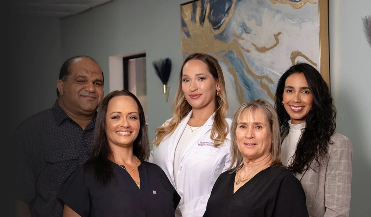 Sunshine Psych Care team of five smiling together in a clinic hallway