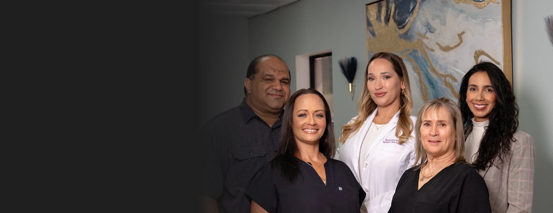 Sunshine Psych Care team of five smiling staff members standing together in a clinical office