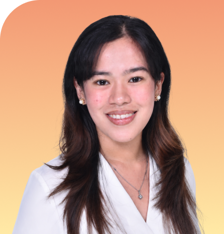 Team member smiling at camera against warm gradient background