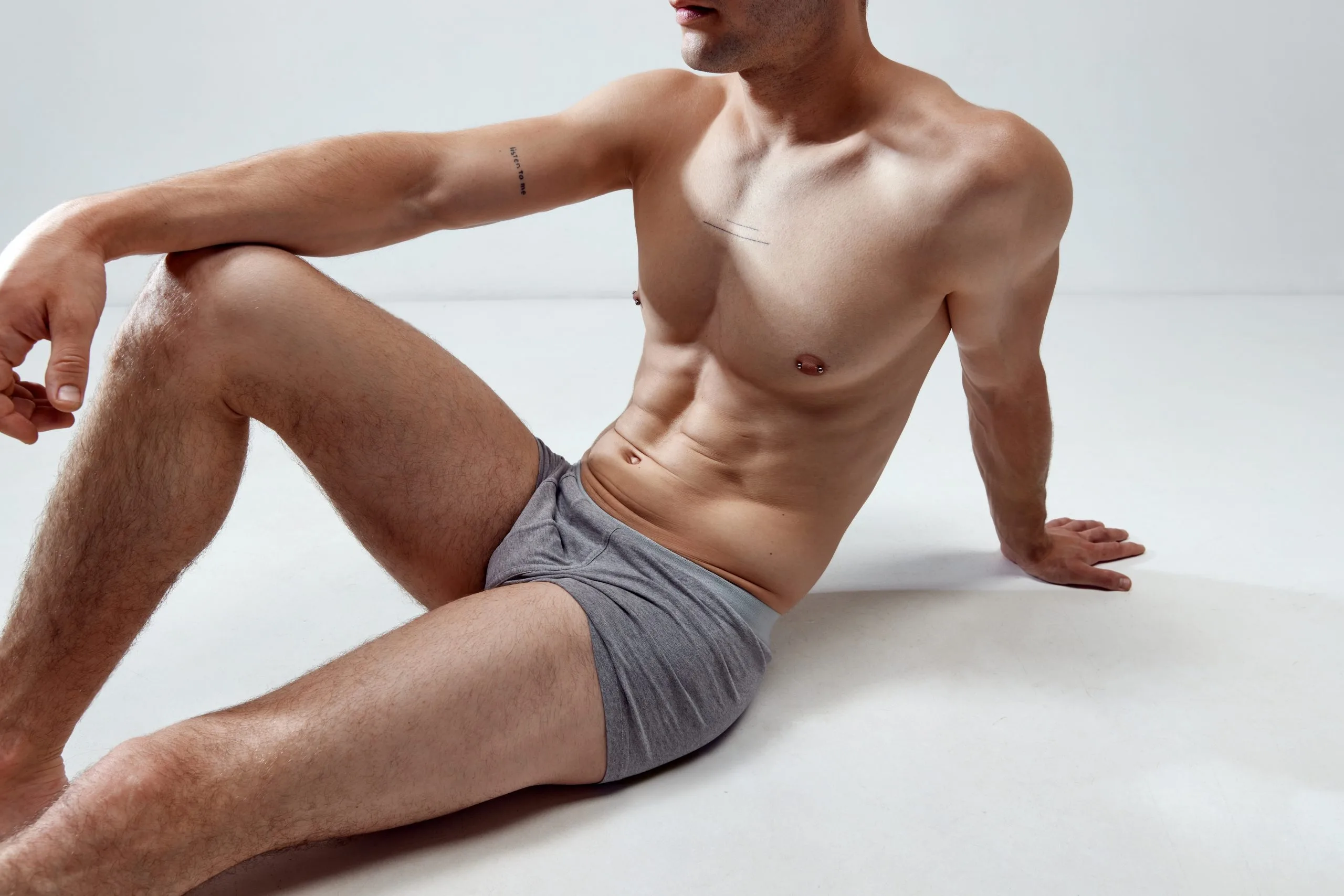 Man in gray underwear reclining on white background