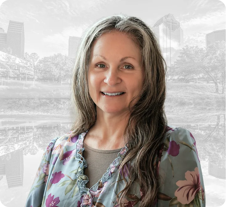 Female staff member smiling at camera with cityscape background