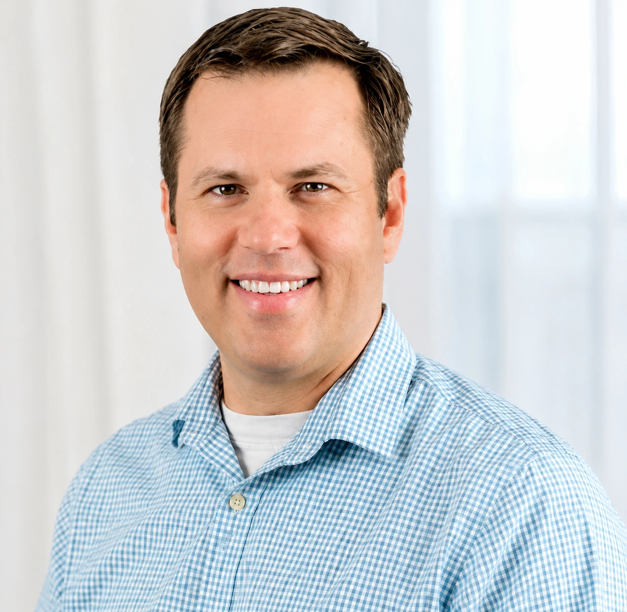 Matt Hanley, psychologist at The Center for ADHD, smiling at camera in blue checkered shirt