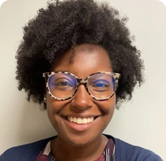 Headshot of a smiling clinician wearing glasses and a dark blue shirt