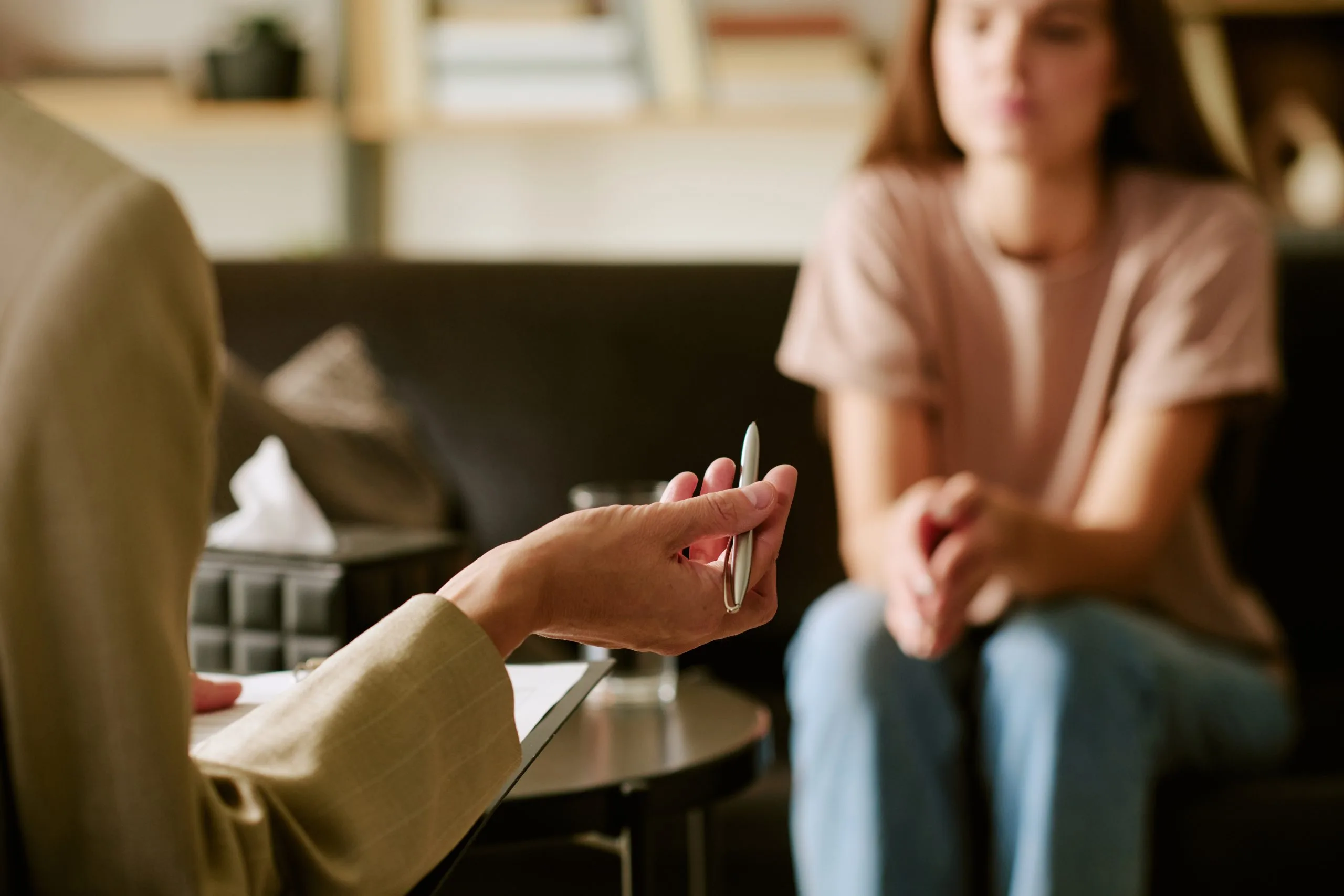 Woman sitting on couch listening during a therapy session