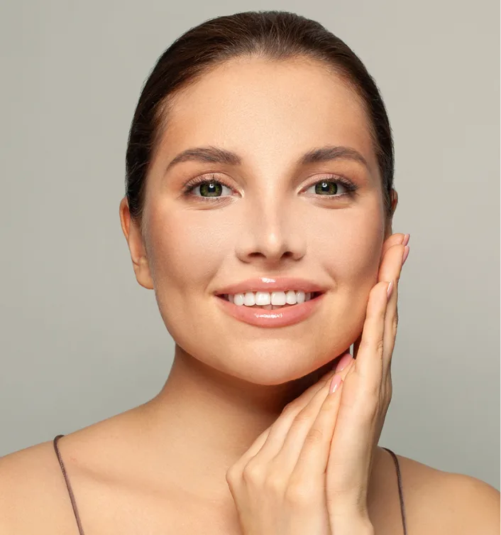 Woman smiling with hand to face, displaying jawline and facial features