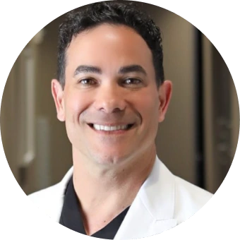 Man in white and black shirt smiling at camera