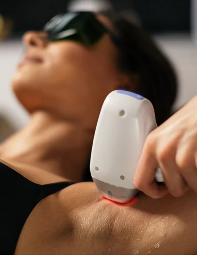 Handheld laser device with red light emitting from tip applied to patient's shoulder