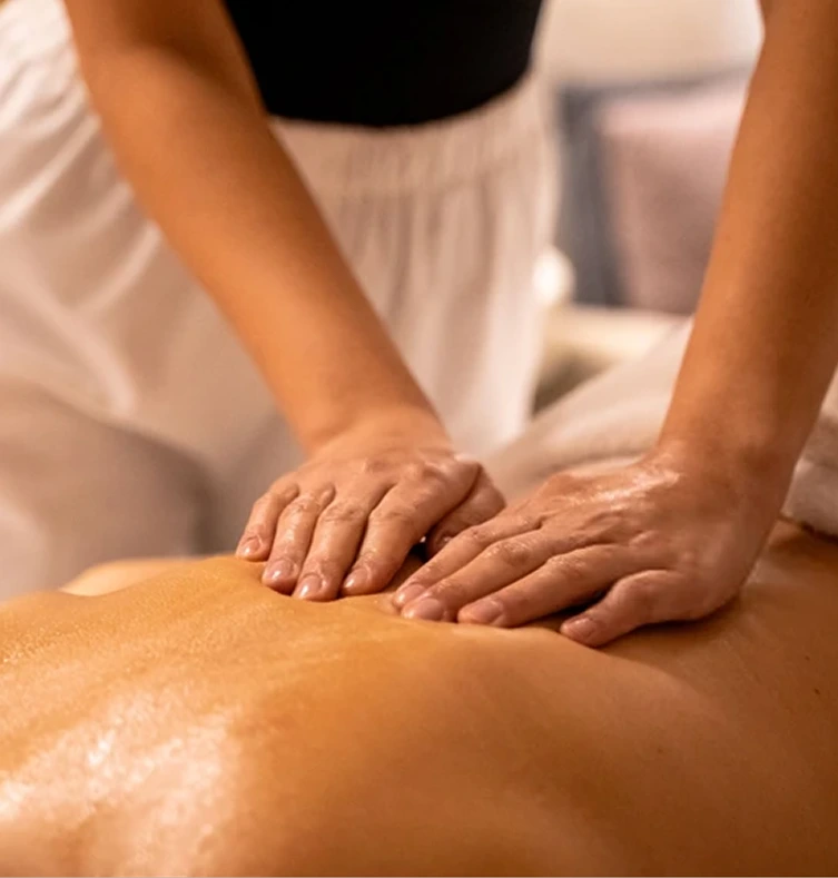 Massage therapist applying pressure to client's back during massage treatment