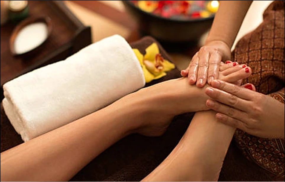 Therapist applying lotion to client's arm during spa massage session