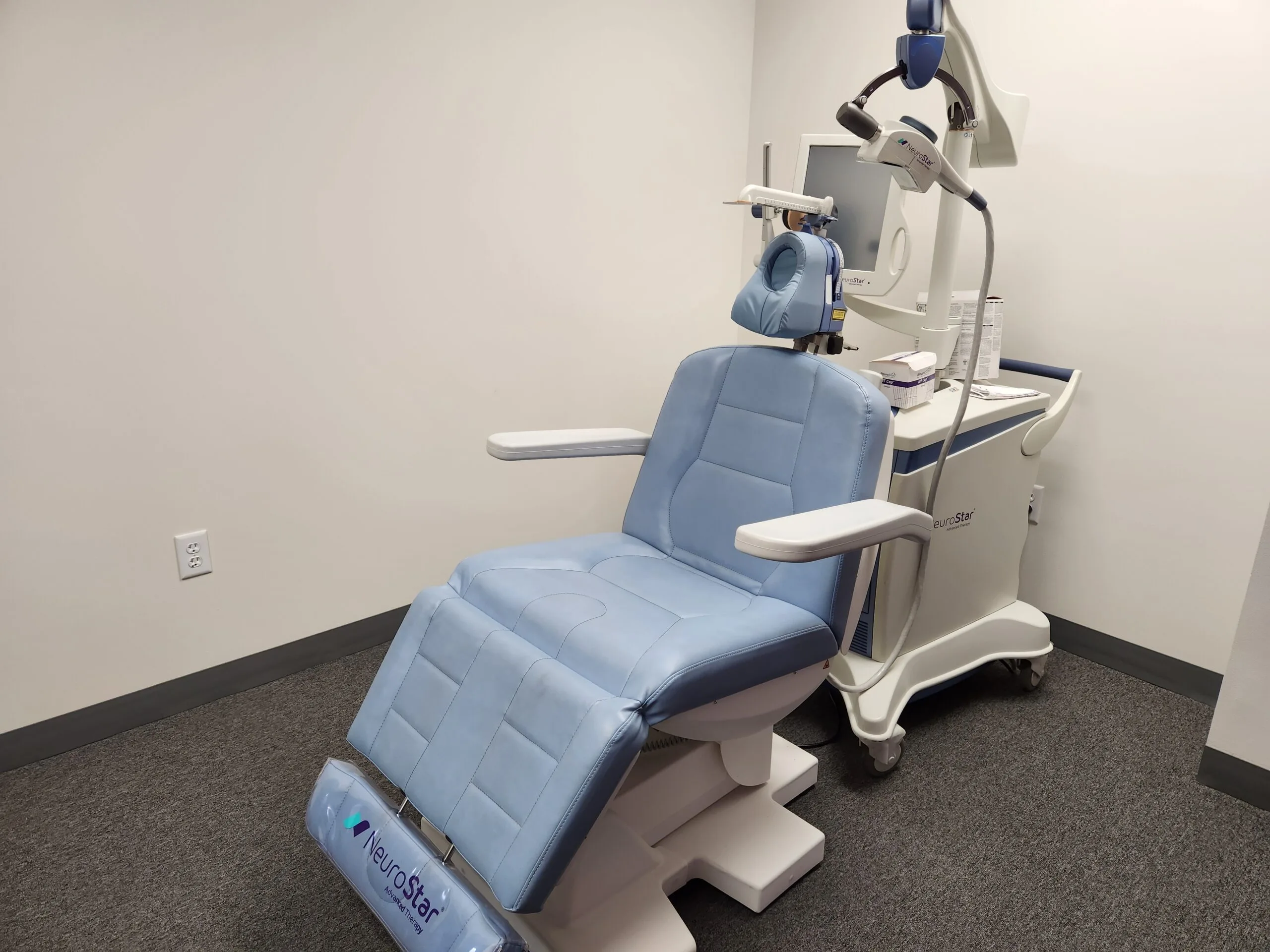 Dental treatment chair with overhead mounted equipment in clinical room