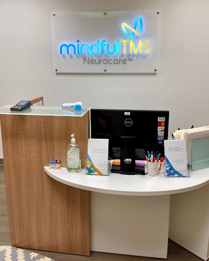 Mindful TMS Neurocare logo on reception desk with wood and white curved counter