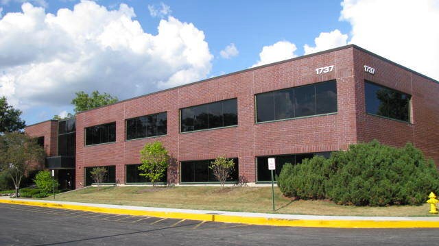 Red brick medical office building with large windows and yellow parking lot curb