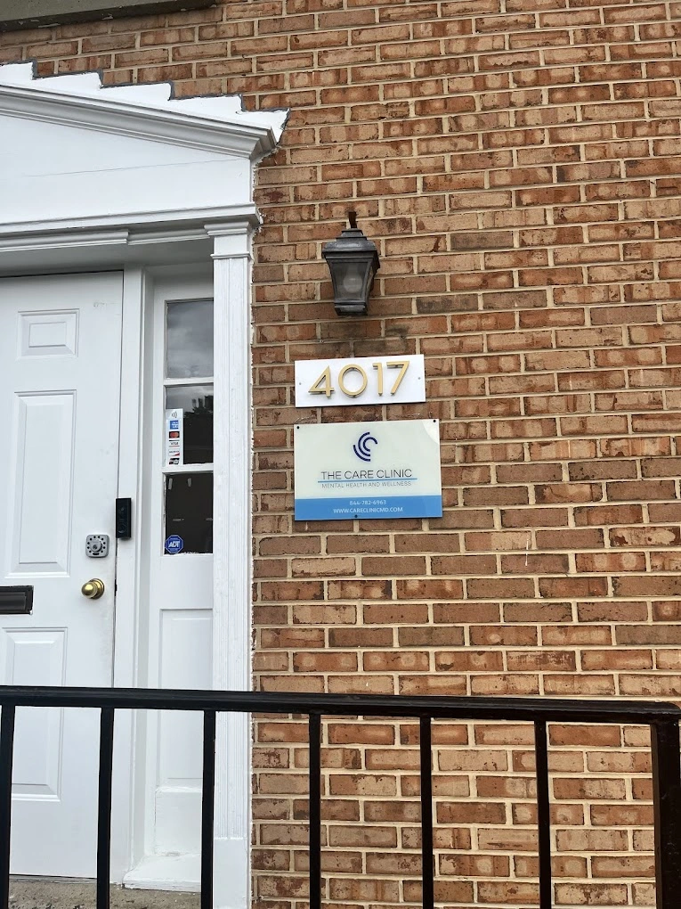 Brick building exterior with white door and trim, address 4017, and The Care Clinic sign