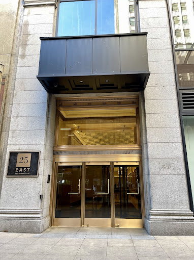 Building entrance at 25 East Delaware with black awning and brass doors
