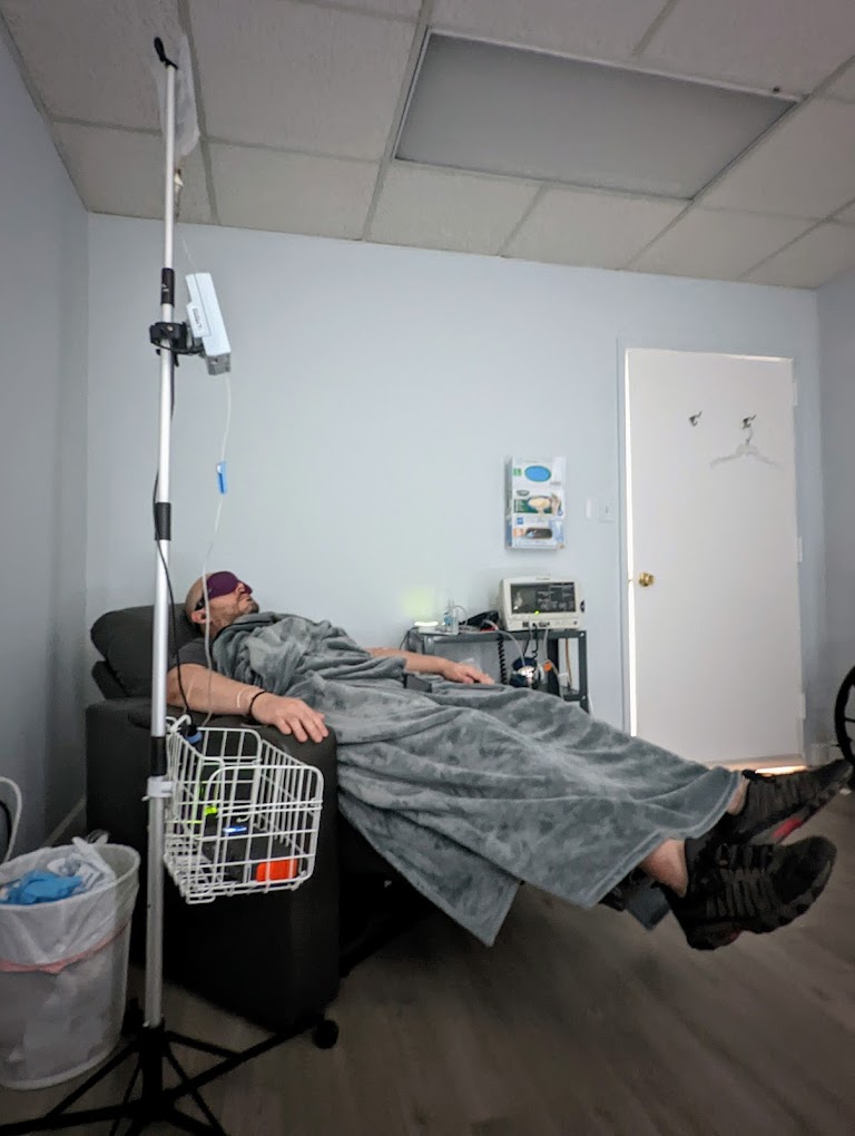 Patient receiving IV infusion therapy while reclining in medical treatment chair