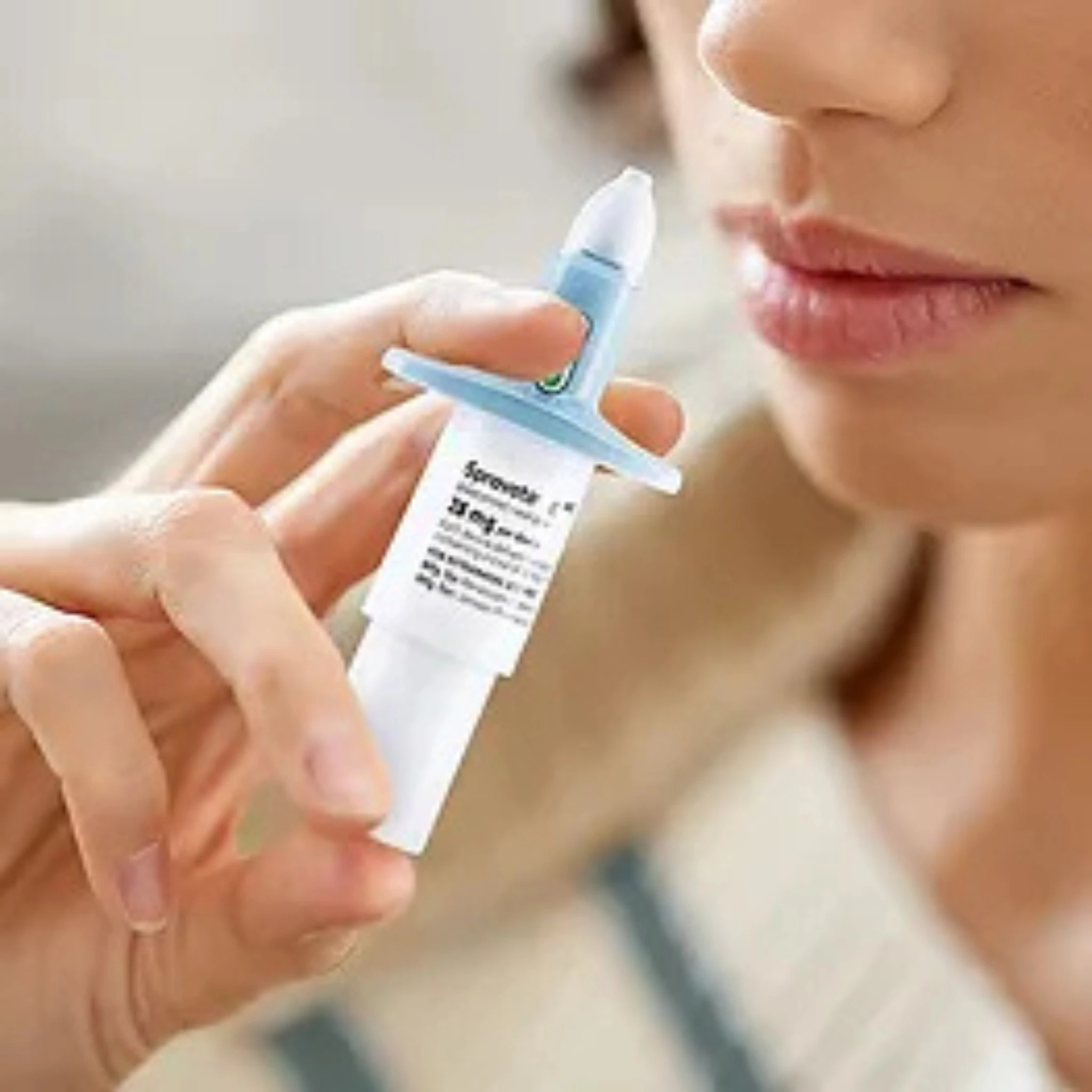 Person holding a blue and white topical applicator near their mouth