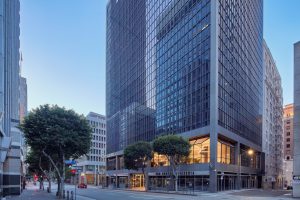 Modern high-rise office building at 800 Wilshire with street-level storefronts and trees