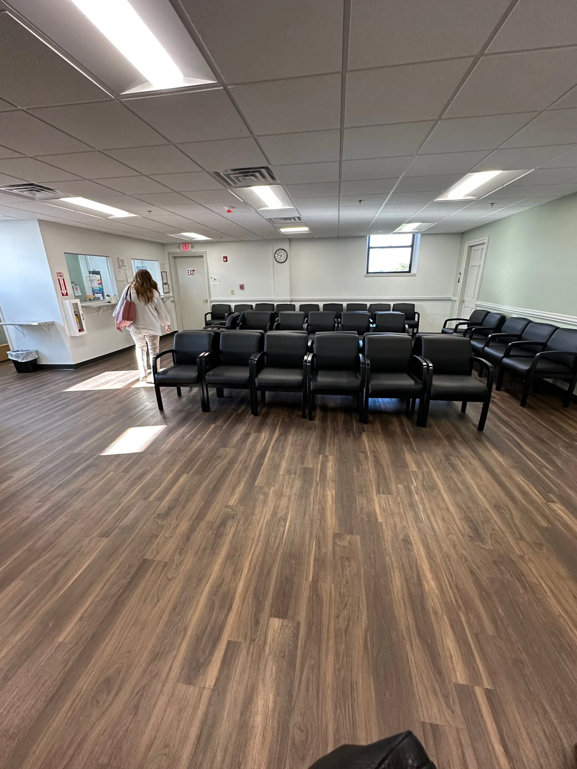 Attleboro clinic waiting room with rows of black chairs and reception desk