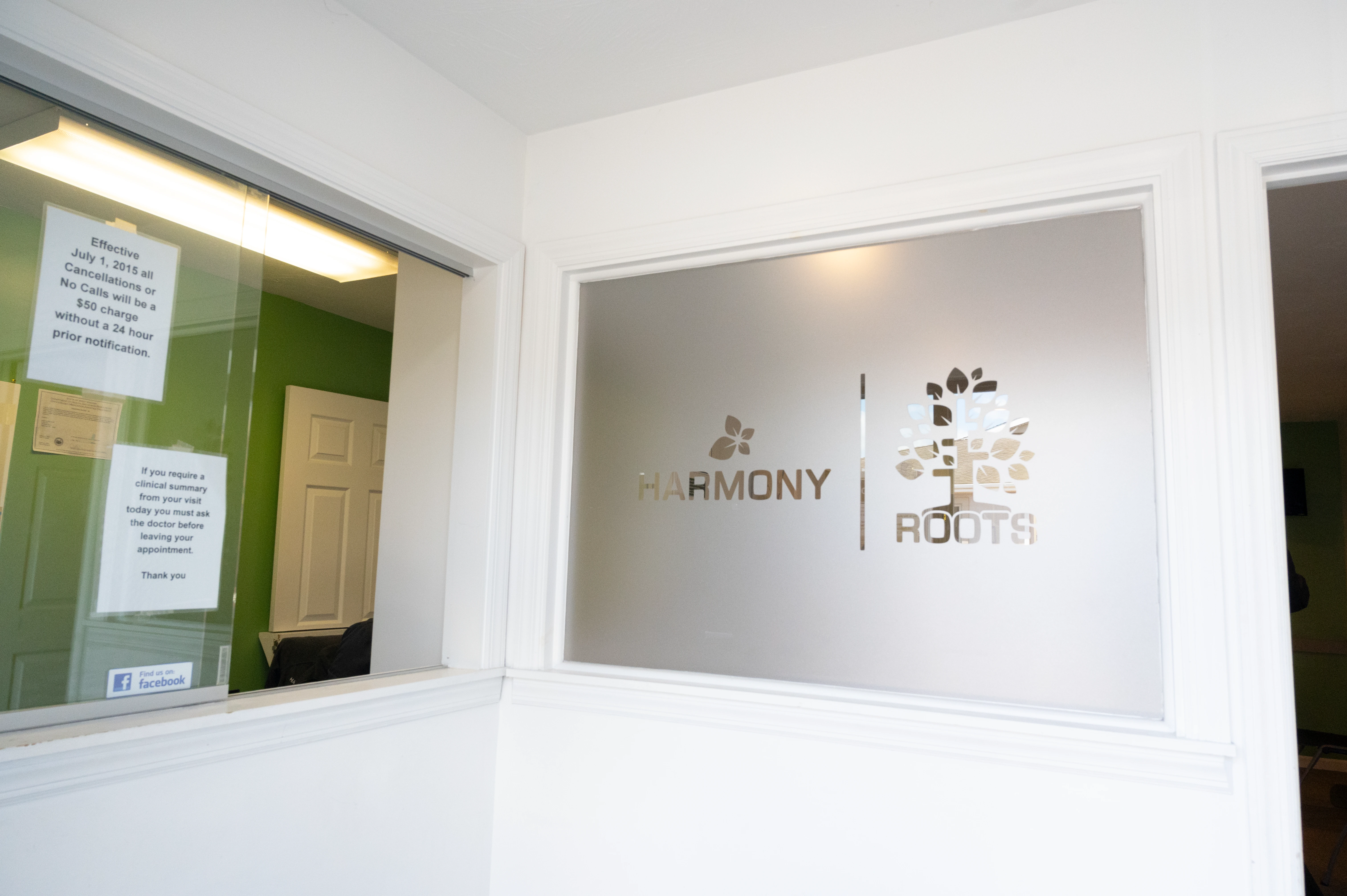 Harmony Roots logo displayed on front desk window at TMS therapy practice