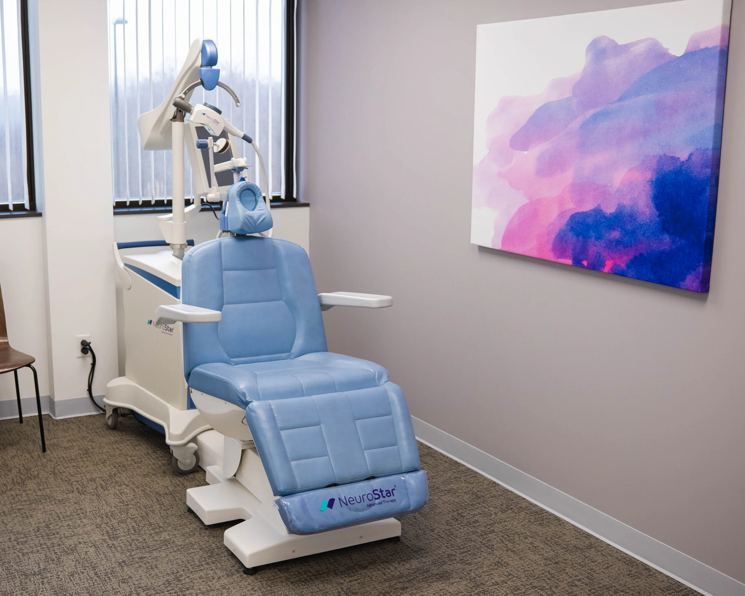 NeuroStar treatment chair in clinical room with colorful abstract wall art