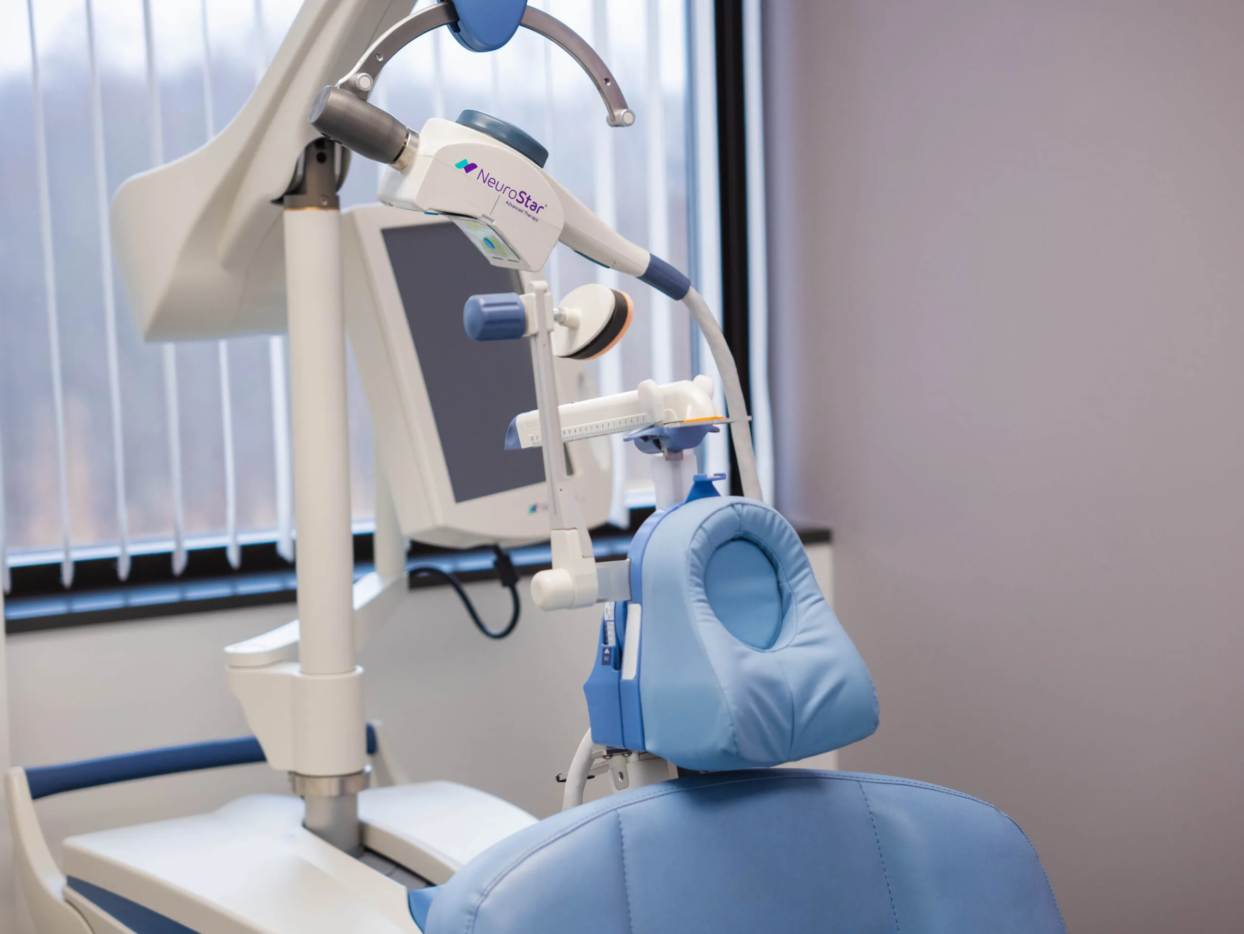 Close-up of NeuroStar treatment coil positioned above patient headrest during TMS session