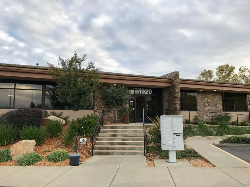 Medical office building entrance at 1020 with landscaping, stone exterior, and mailbox