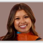 Jasmin, smiling woman with long brown hair wearing orange top