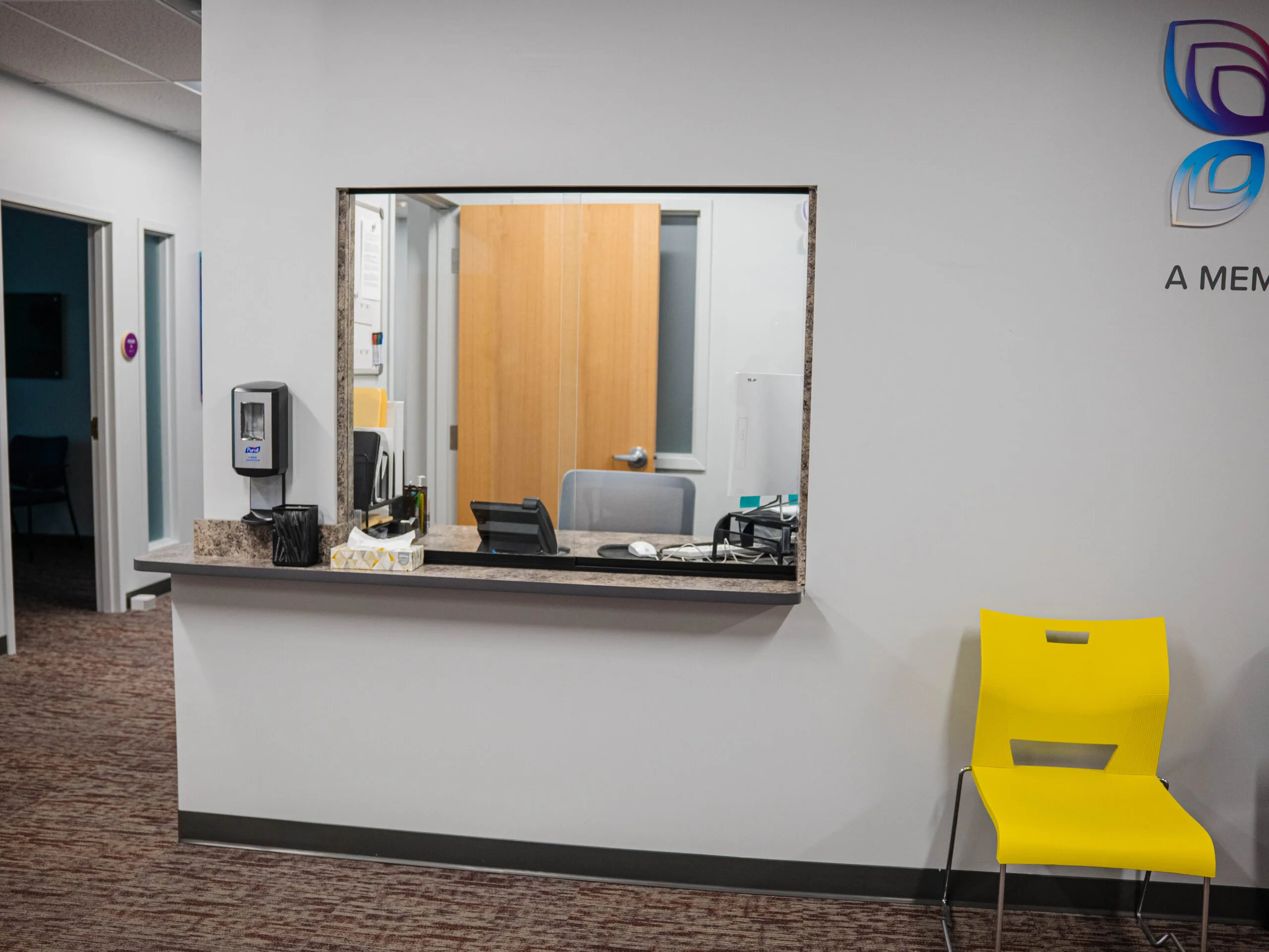 Reception desk with mirror and yellow patient chair in Northeast Health Services clinic