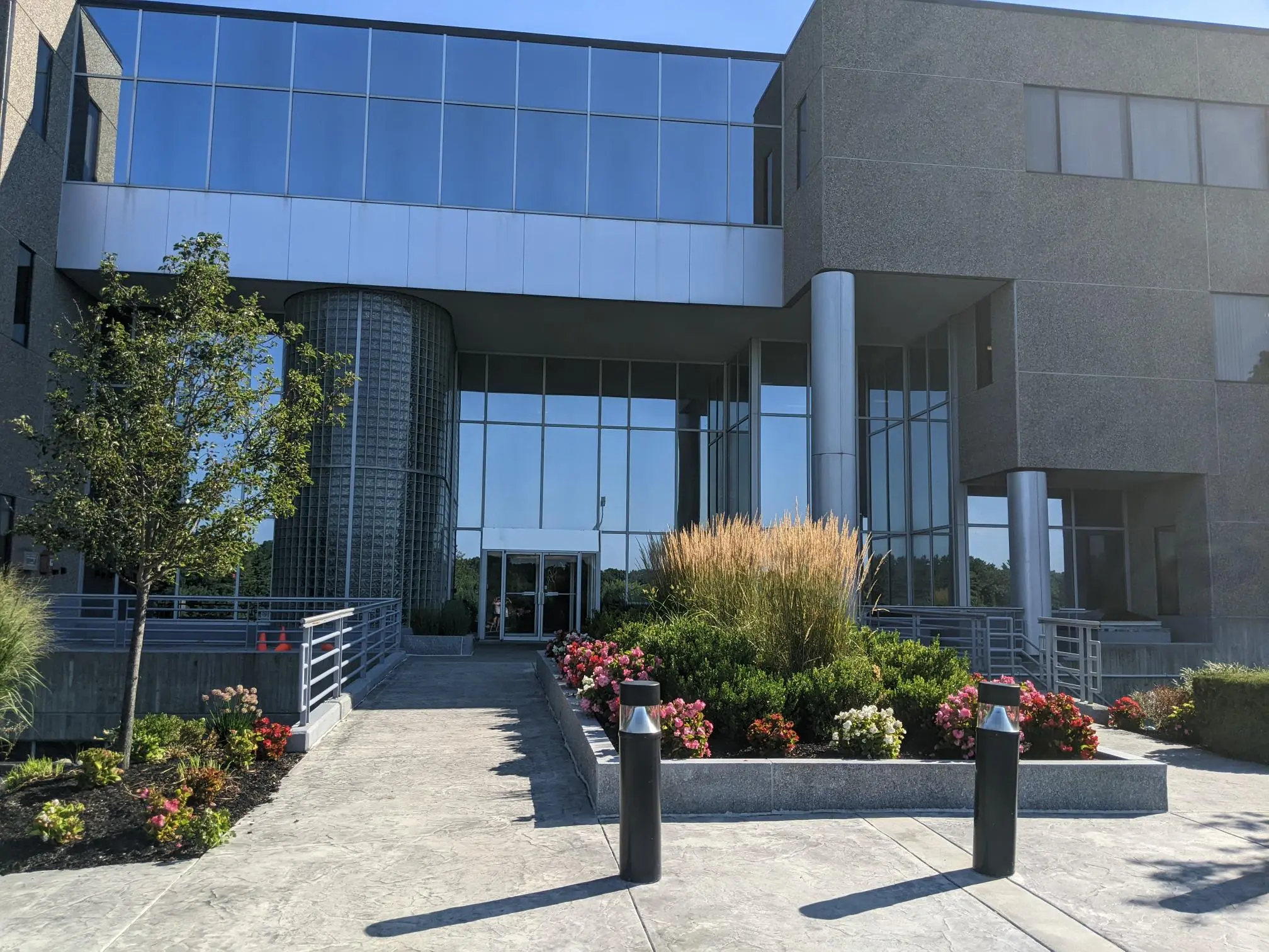 Modern glass and brick medical office building exterior with landscaped entrance and clear blue sky