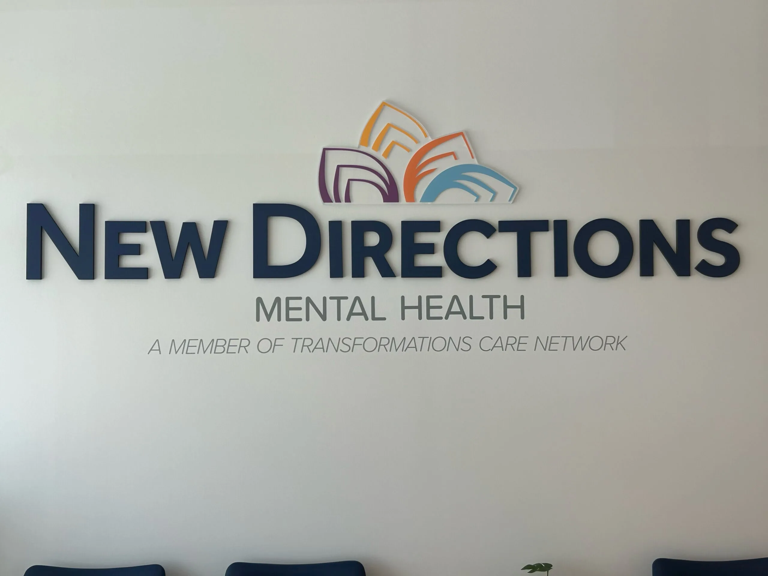 New Directions Mental Health interior signage with colorful logo and network affiliation text