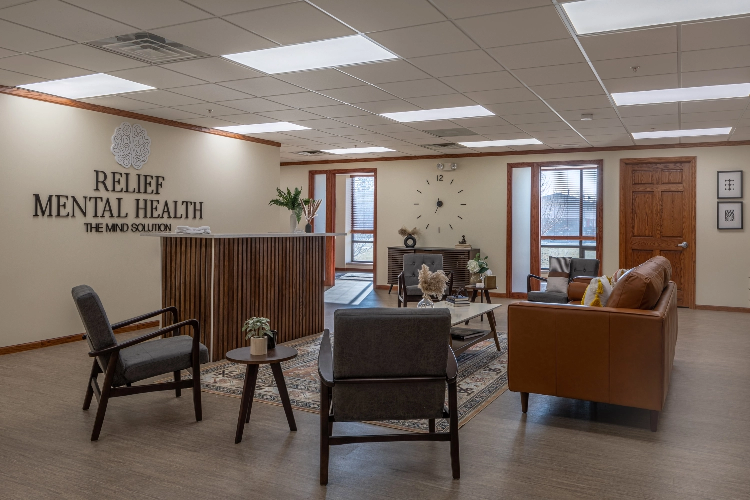 Relief Mental Health clinic reception area with logo on wall, waiting seating, reception desk, and windows