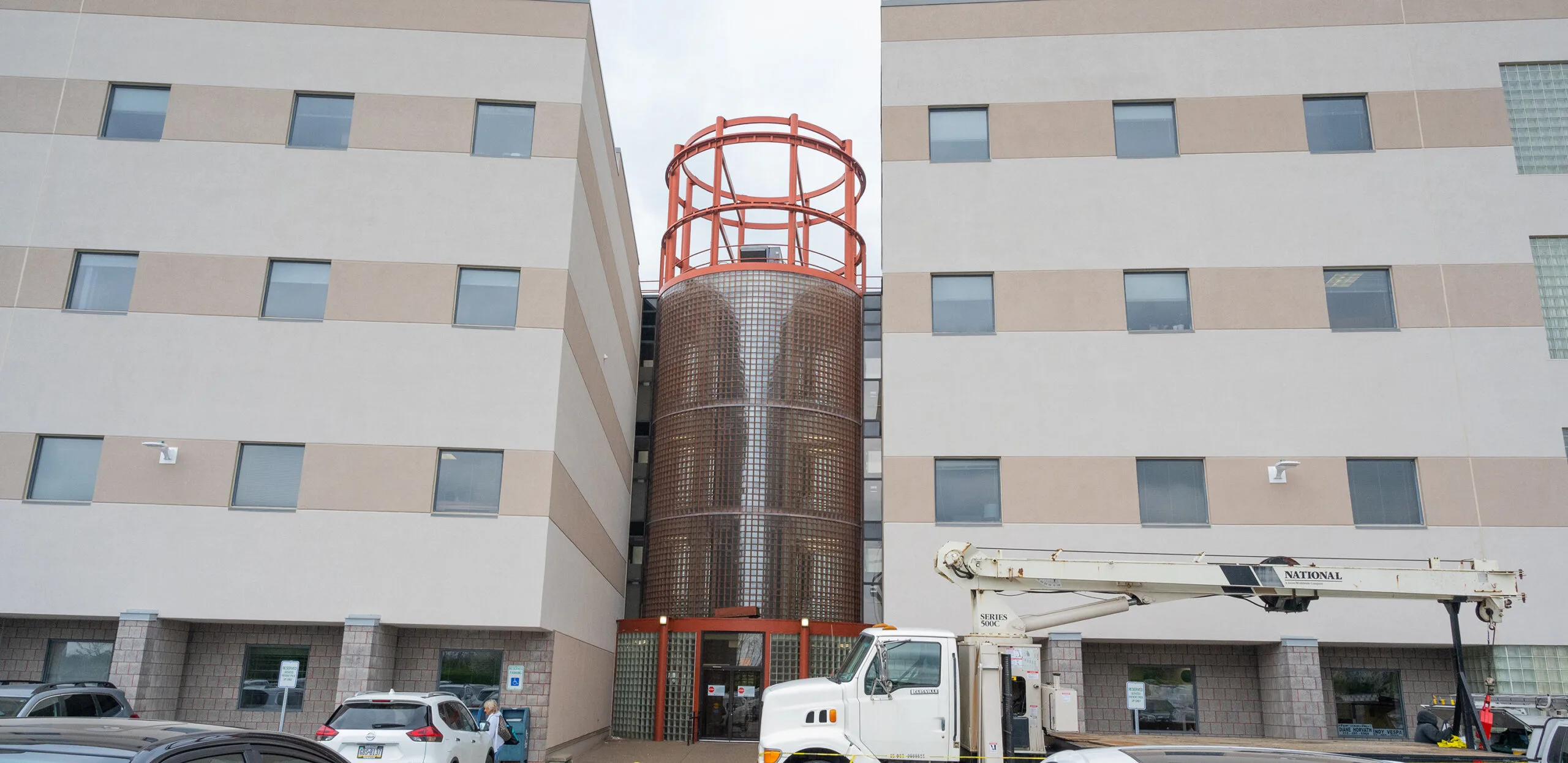 South Hills clinic exterior multi-story building with tan and white facade, red water tower on roof, and utility truck parked at entrance
