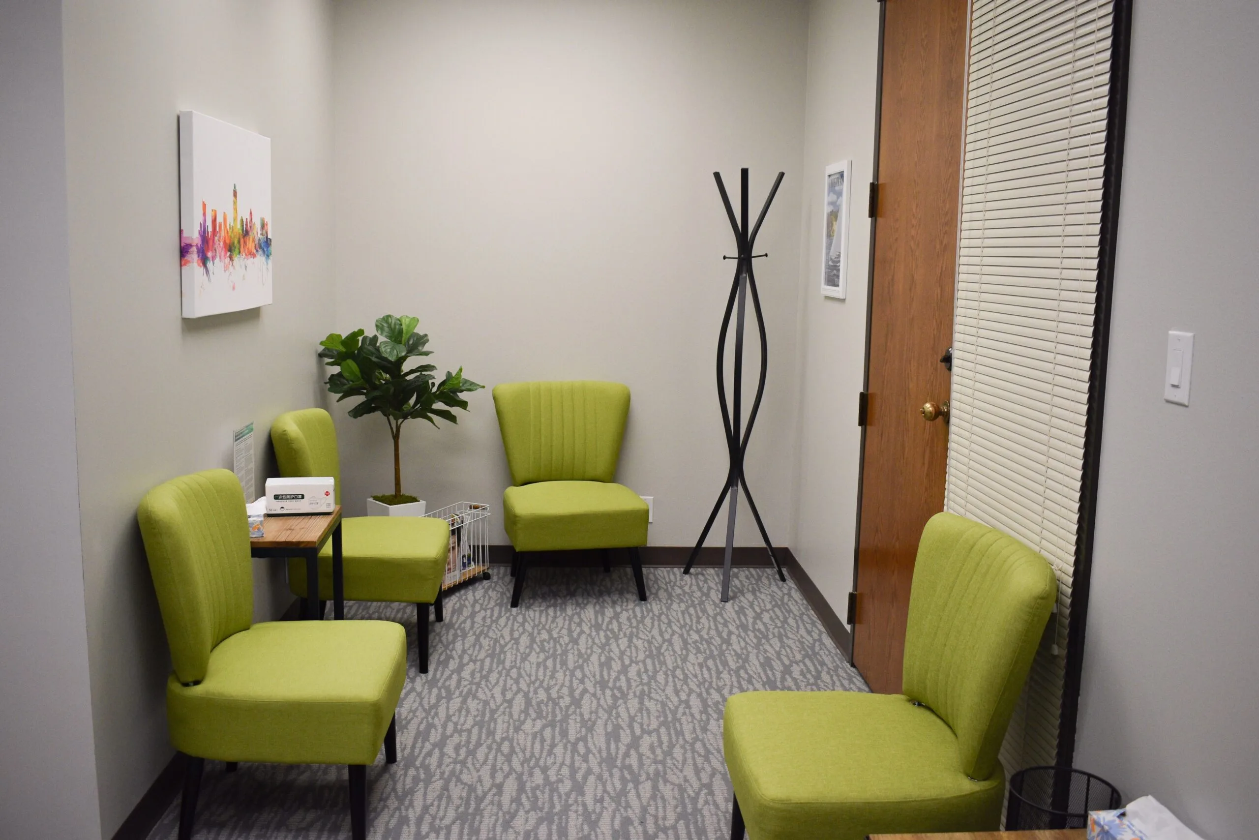 Westlake reception area with lime green chairs, potted plant, and modern black coat stand