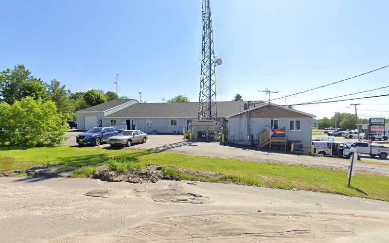 Single-story clinical building with parking lot and communication tower visible