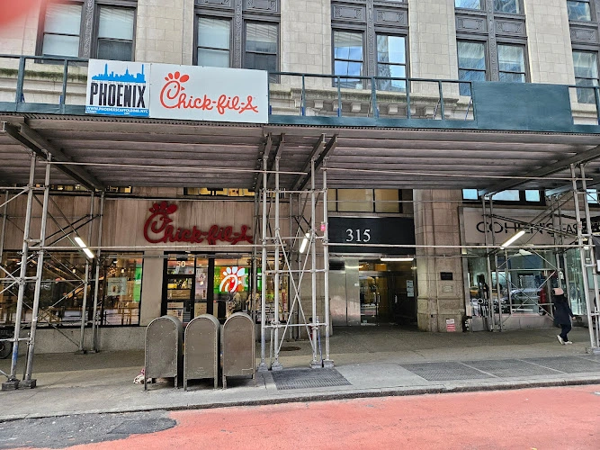 Phoenix storefront with Chick-fil-A signage and construction scaffolding on urban street