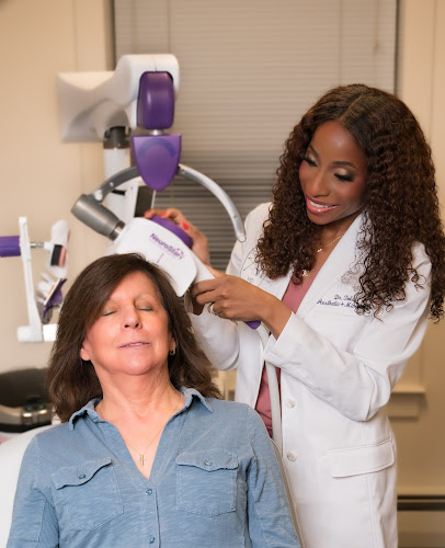 Healthcare provider in white coat administering TMS treatment to seated patient