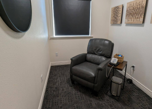 Private treatment room at American Fork location with black reclining chair, window, and small side table