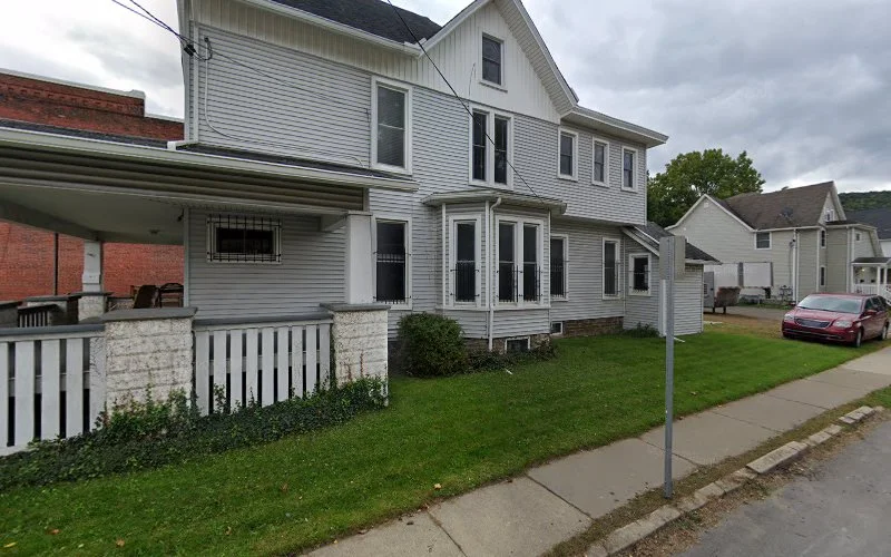 White two-story house with front porch and covered entrance serving as therapy office